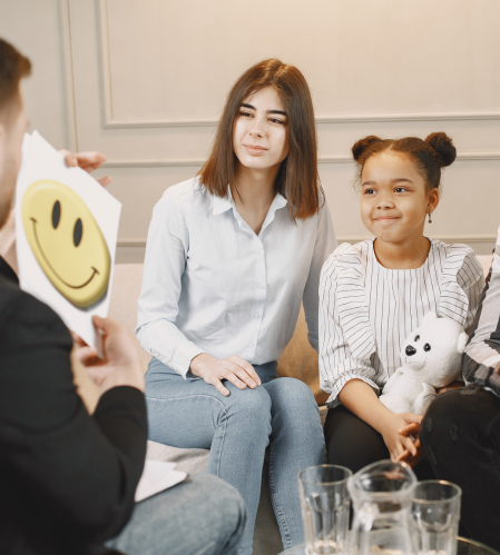 Child in Lancaster, PA participating in neurofeedback therapy session with EEG sensors while therapist and parent provide supportive guidance