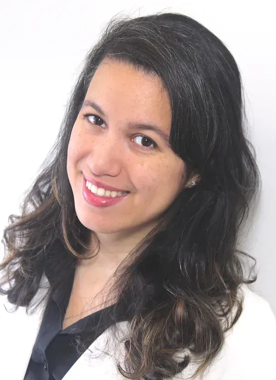Dr. Jennifer Diaz, Doctor of Chiropractic, smiling in a professional setting, wearing a white coat, representing holistic health and patient-centered care at Apex Chiropractic & Wellness Center.